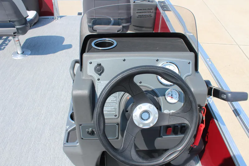 Slide: The Image of 2026 Sun Tracker Bass Buggy 18 DLX steering console with gauges and cup holder. - 16