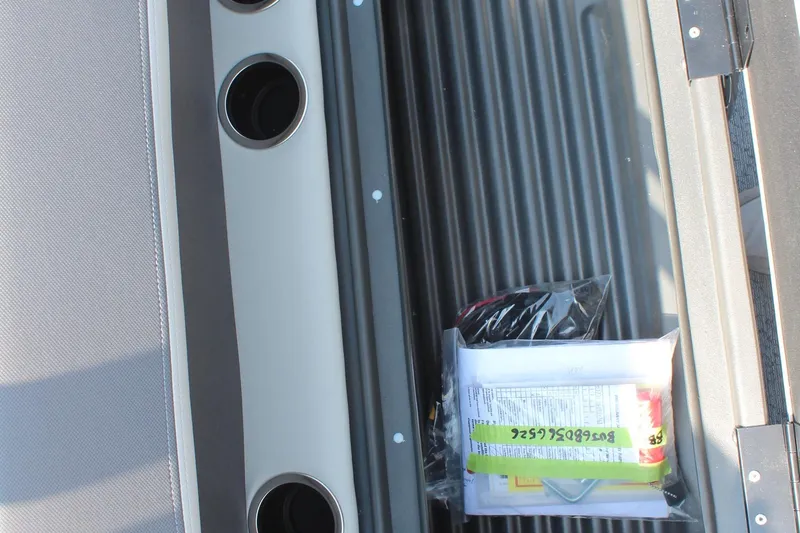 Slide: The Image of Interior view of 2026 Sun Tracker Bass Buggy 18 DLX with storage compartment and cup holders. - 22