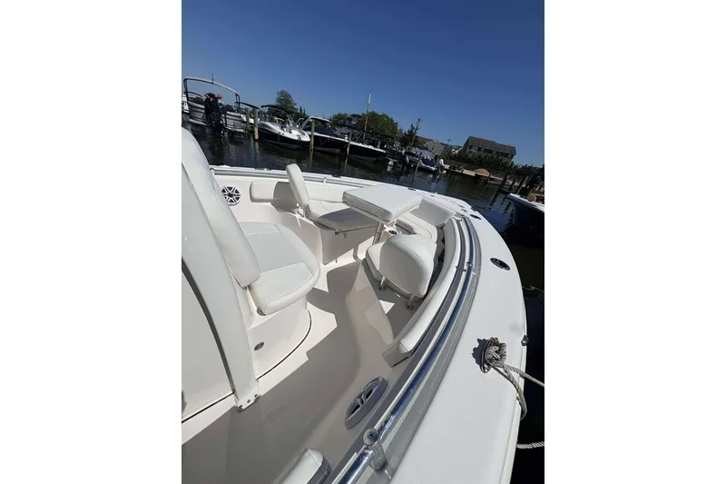 Slide: The Image of 2026 Key West 219 FS boat interior with seating and table at a marina. - 13