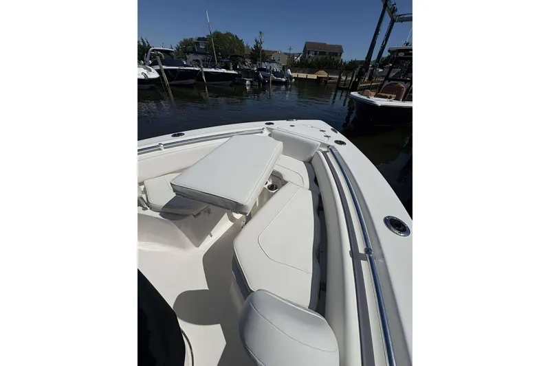 Slide: The Image of 2026 Key West 219 FS boat interior with white seating, docked at marina. - 14