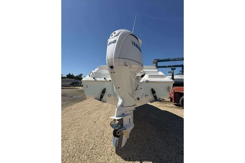 Slide: The Image of 2026 Key West 219 FS boat with Yamaha outboard motor, parked on gravel. - 19