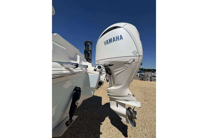 Slide: The Image of 2026 Key West 219 FS boat with Yamaha outboard motor, parked on gravel. - 20