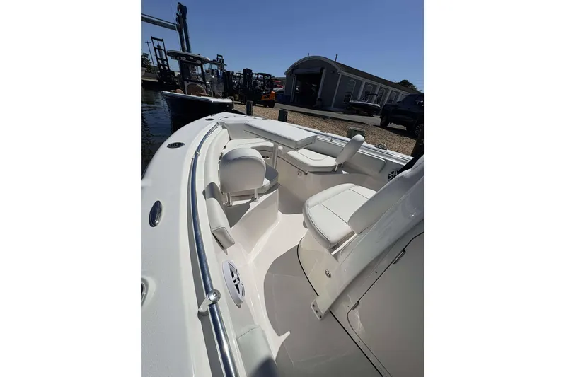 Slide: The Image of 2026 Key West 219 FS boat interior with seating and railings, docked near a marina. - 6