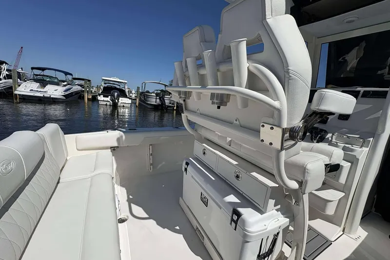 Slide: The Image of 2026 Key West 219 FS boat interior with white seating and storage, docked at marina. - 8