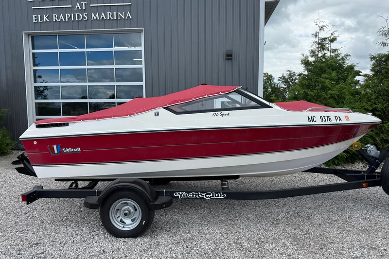 Slide: The Image of 1991 Wellcraft 170 Sport boat with red cover on trailer at Elk Rapids Marina. - 2