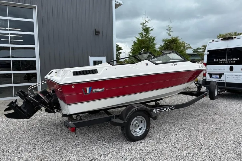 Slide: The Image of 1991 Wellcraft 170 Sport boat on trailer, parked outside a marina building. - 4