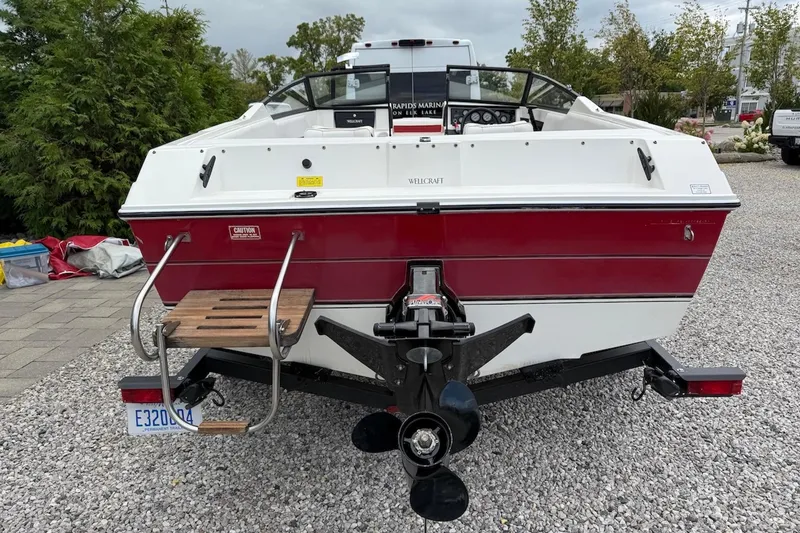 Slide: The Image of 1991 Wellcraft 170 Sport boat, red and white, rear view on gravel. - 5