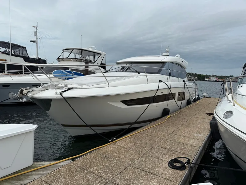 The Image of 2018 Prestige 500 S yacht docked at marina under cloudy sky. - 0