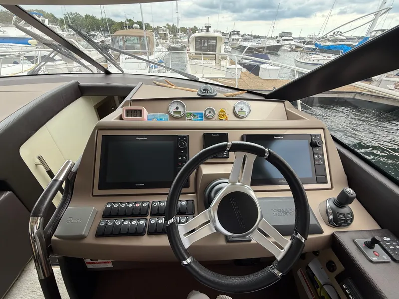 Slide: The Image of Helm of 2018 Prestige 500 S yacht with navigation controls and marina view. - 11
