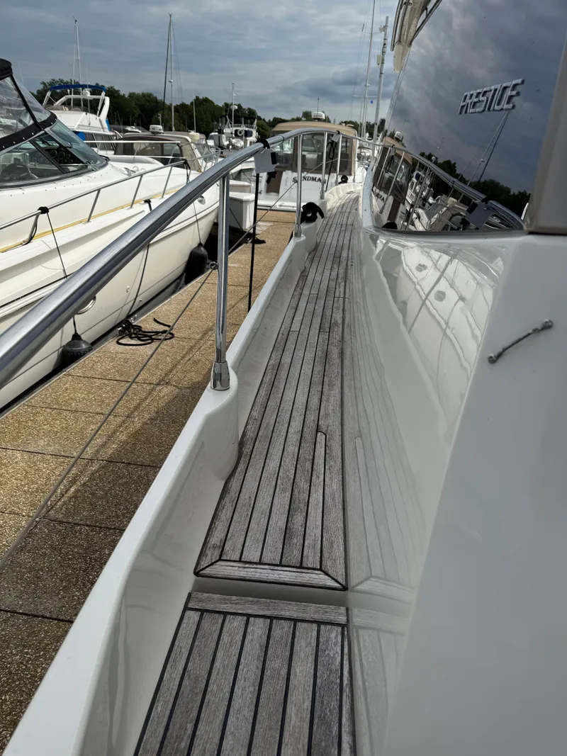 Slide: The Image of 2018 Prestige 500 S yacht docked, featuring sleek wooden deck and polished railings. - 14