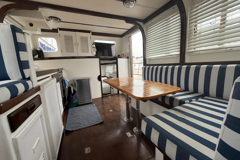 Slide: The Image of Interior of a 1978 CHB 34 boat with striped seating and wooden table. - 13