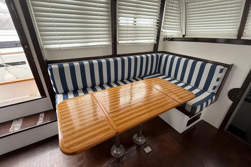 Slide: The Image of 1978 CHB 34 interior with striped seating and wooden table, surrounded by blinds. - 16
