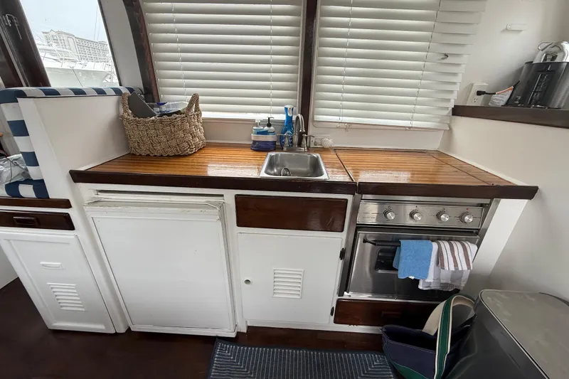 Slide: The Image of 1978 CHB 34 boat kitchen with wooden countertops, sink, and stove. - 17