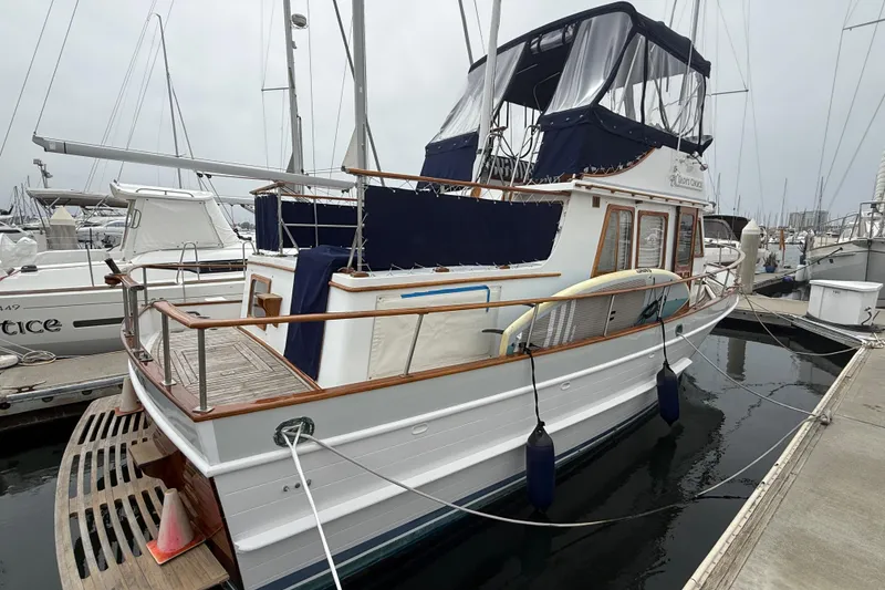 Slide: The Image of 1978 CHB 34 yacht docked at marina, featuring wooden accents and blue canopy. - 2