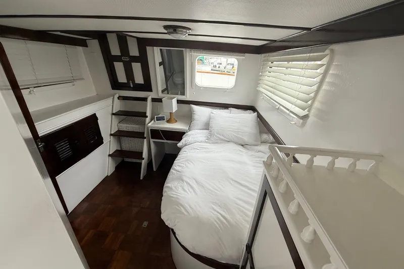 Slide: The Image of Cozy cabin interior of 1978 CHB 34 boat with bed, window, and wooden accents. - 20