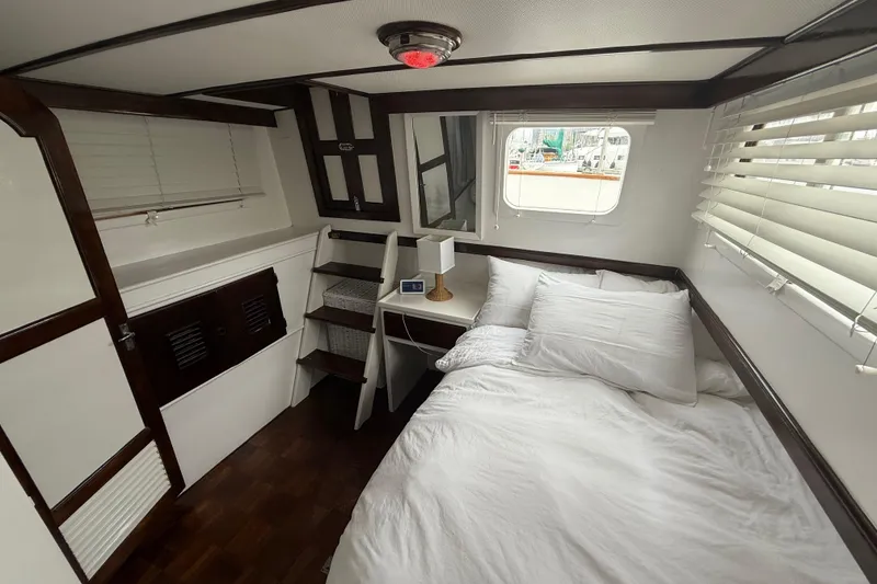 Slide: The Image of Cozy cabin interior of 1978 CHB 34 boat with bed, window, and wooden accents. - 21
