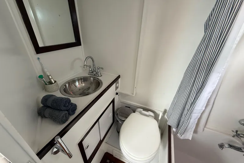 Slide: The Image of 1978 CHB 34 yacht bathroom with sink, mirror, and toilet. - 23