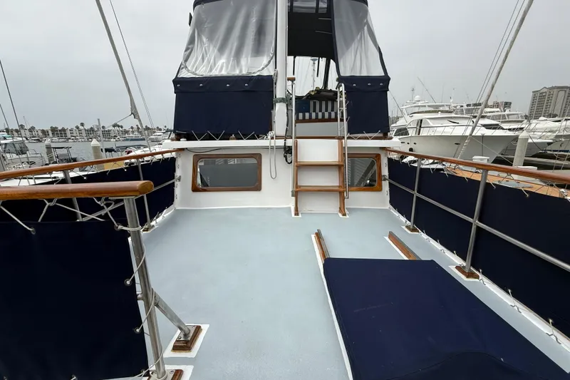 Slide: The Image of 1978 CHB 34 yacht deck with blue canvas, wooden railings, and marina view. - 24