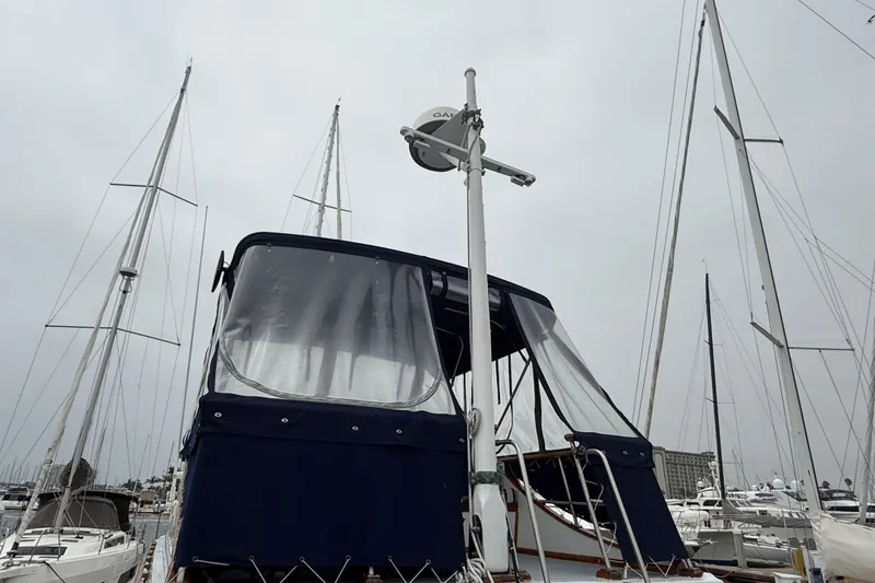 Slide: The Image of 1978 CHB 34 boat with blue canopy docked at marina, surrounded by sailboats. - 25