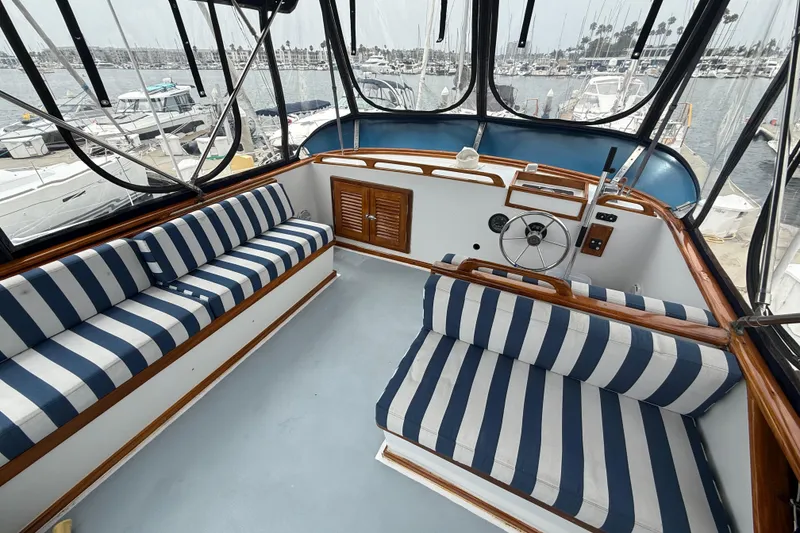 Slide: The Image of 1978 CHB 34 boat interior with striped seating and steering wheel, docked at marina. - 26