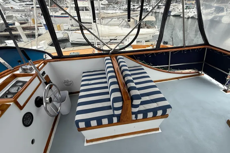Slide: The Image of 1978 CHB 34 boat interior with striped seating and steering wheel, docked at marina. - 27