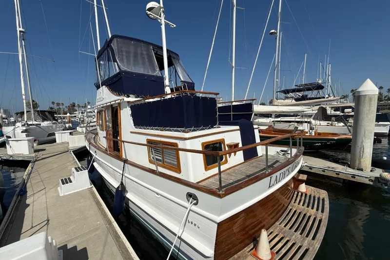 Slide: The Image of 1978 CHB 34 boat docked at marina, featuring wooden accents and blue canopy. - 3