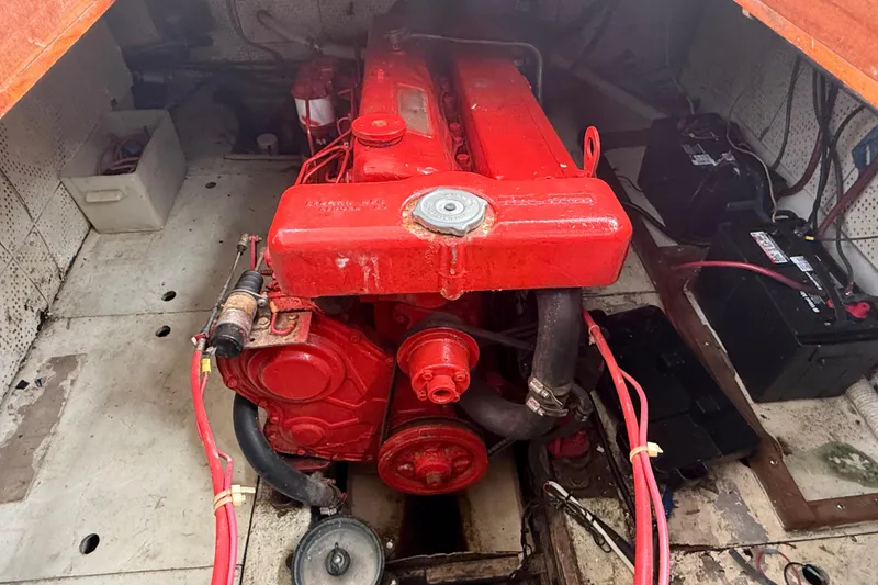 Slide: The Image of Red engine inside a 1978 CHB 34 boat, surrounded by wiring and batteries. - 30