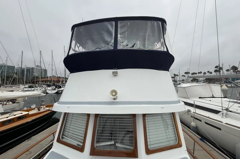 Slide: The Image of 1978 CHB 34 boat docked at marina, surrounded by sailboats under cloudy sky. - 5