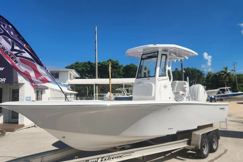 Slide: The Image of 2026 Tidewater 2500 Carolina Bay boat on trailer, displayed outdoors under clear blue sky. - 3