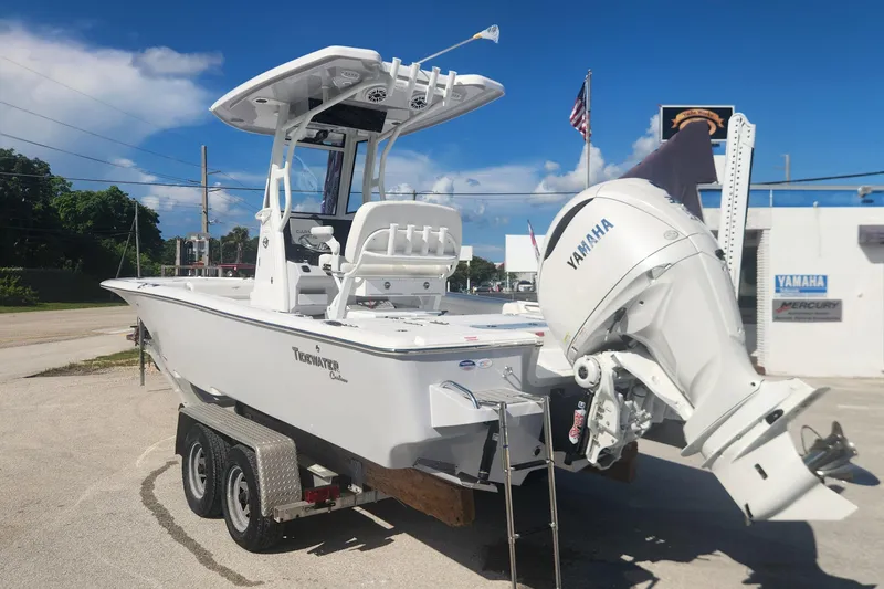 Slide: The Image of 2026 Tidewater 2500 Carolina Bay boat with Yamaha engine on trailer, parked outdoors. - 6