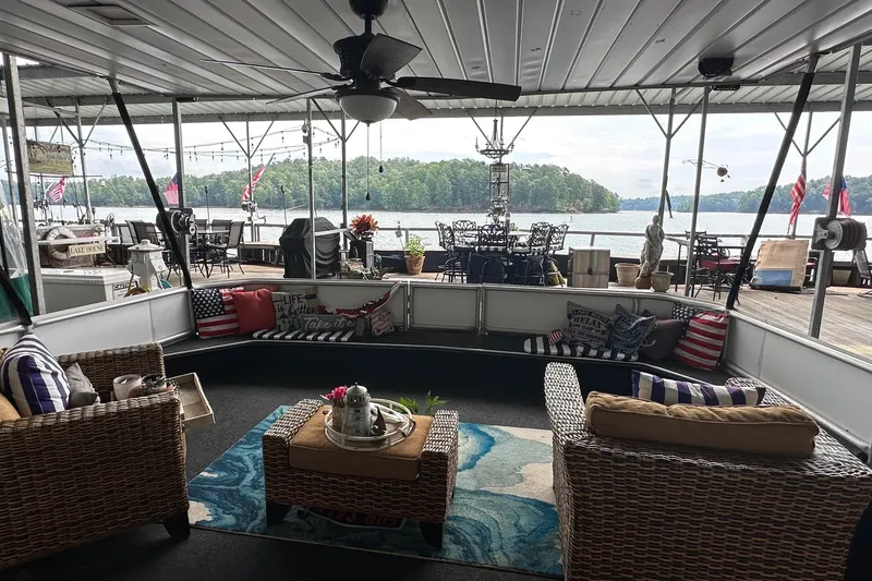 Slide: The Image of Houseboat interior with wicker furniture, lake view, and patriotic decor, Stardust Cruisers 16x78, 1997 model. - 1