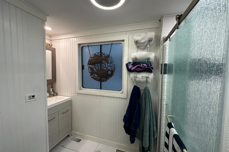 Slide: The Image of Bathroom interior of 1997 Stardust Cruisers 16x78 houseboat with towels and decorative window. - 10