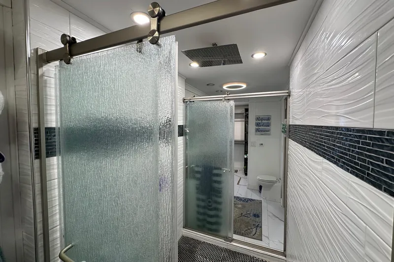 Slide: The Image of Luxurious bathroom in 1997 Stardust Cruisers 16x78 houseboat with modern shower and elegant tiles. - 11