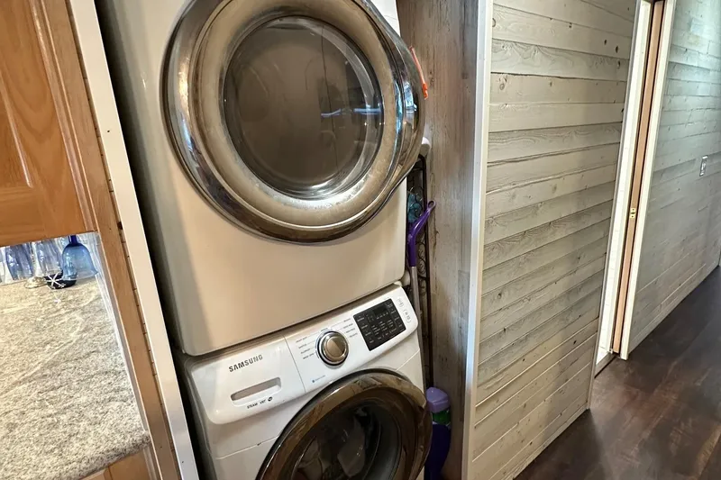 Slide: The Image of Stacked Samsung washer and dryer in a narrow hallway of a 1997 Stardust Cruisers 16x78. - 14