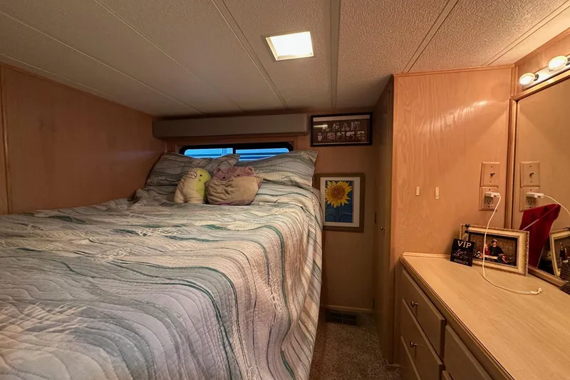 Slide: The Image of Cozy bedroom in 1997 Stardust Cruisers 16x78 houseboat with plush toys and sunflower art. - 6