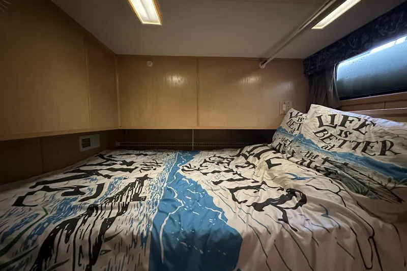Slide: The Image of Cozy bedroom in 1997 Stardust Cruisers houseboat with themed bedding and wooden paneling. - 7