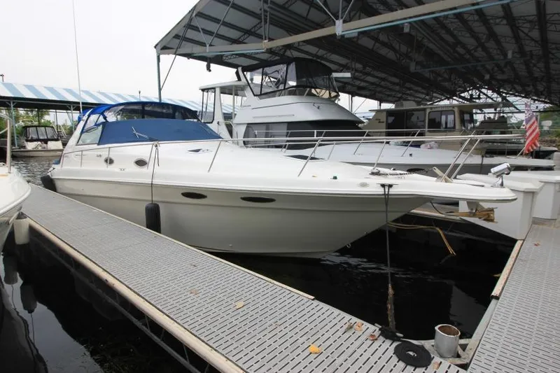 The Image of 1998 Sea Ray 330 Sundancer docked in a marina under a covered structure. - 0