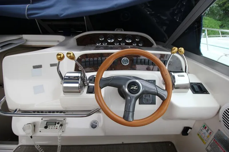 Slide: The Image of 1998 Sea Ray 330 Sundancer helm with wooden steering wheel and control panel. - 10