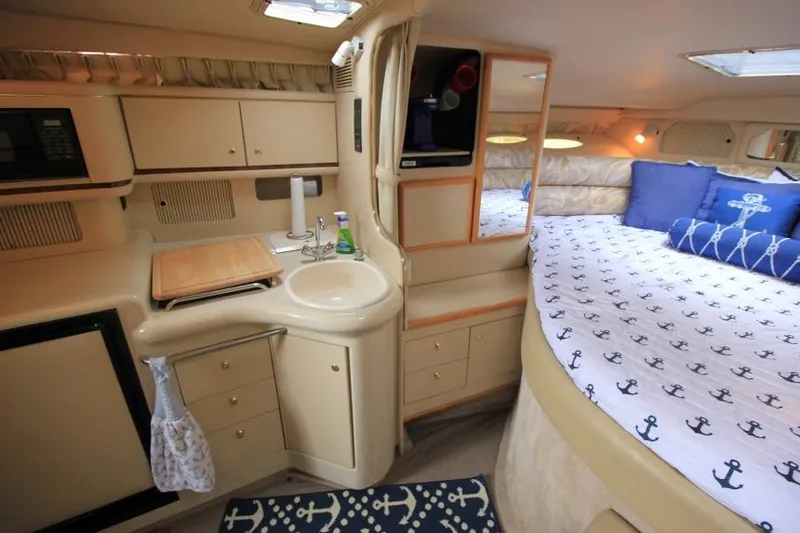Slide: The Image of 1998 Sea Ray 330 Sundancer cabin interior with kitchenette and cozy sleeping area. - 13