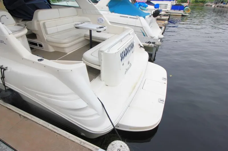 Slide: The Image of 1998 Sea Ray 330 Sundancer docked, featuring spacious seating and swim platform. - 3