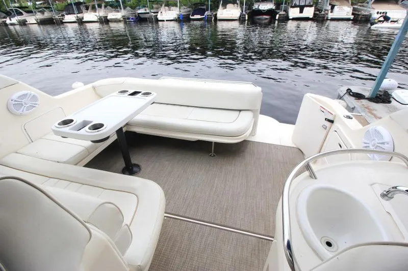Slide: The Image of 1998 Sea Ray 330 Sundancer boat interior with seating, table, and sink by the water. - 7
