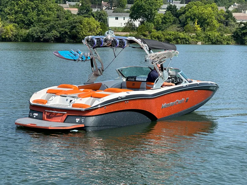 Slide: The Image of 2015 MasterCraft X23 boat on a lake with wakeboards. - 13