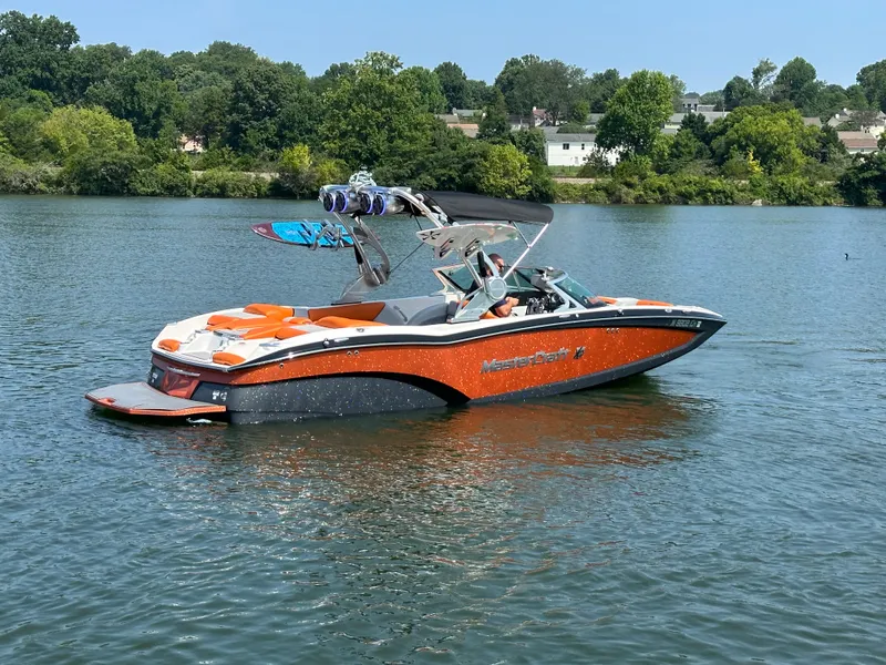 Slide: The Image of 2015 MasterCraft X23 boat on a lake with wakeboard tower and orange accents. - 4