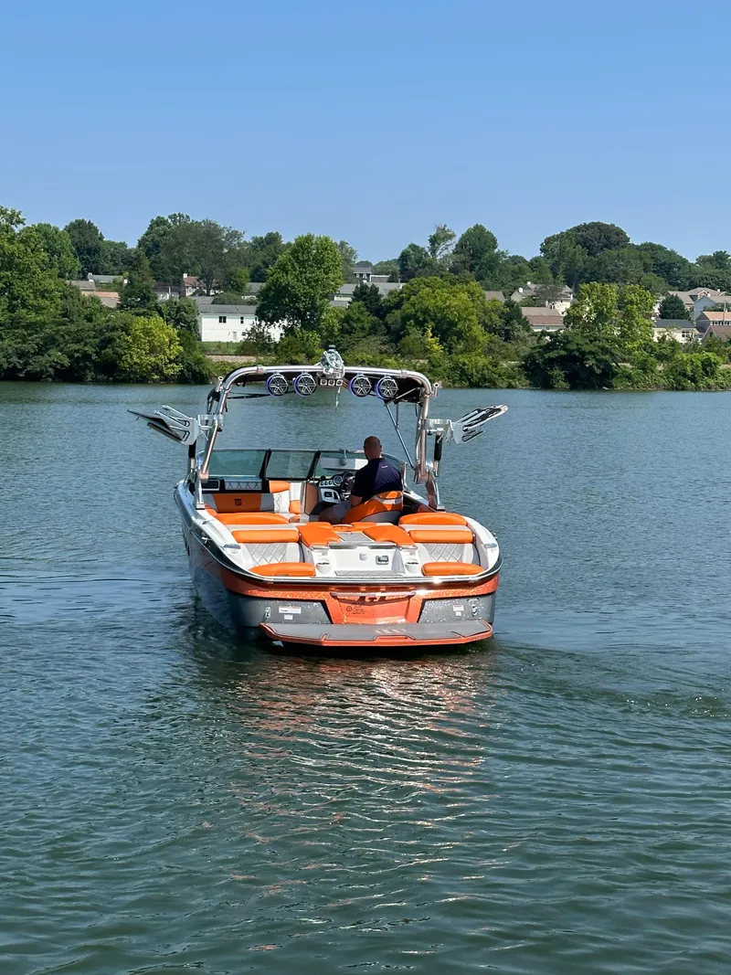 Slide: The Image of 2015 MasterCraft X23 boat cruising on a lake with a scenic background. - 5