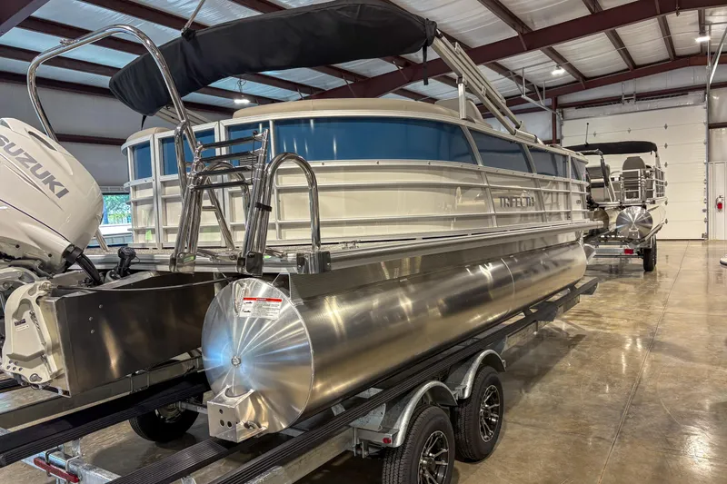 Slide: The Image of 2025 Trifecta 20RF LE pontoon boat in a showroom with Suzuki outboard motor. - 3