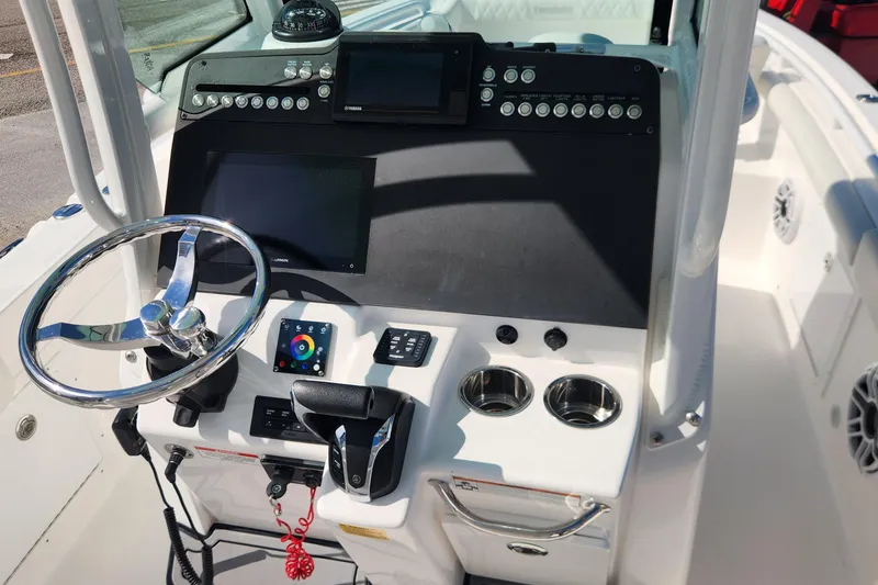 Slide: The Image of 2022 Everglades 235 Center Console boat dashboard with steering wheel and control panel. - 15