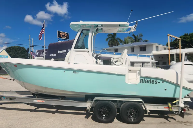 Slide: The Image of 2022 Everglades 235 Center Console boat on trailer, displayed outdoors under clear blue sky. - 4