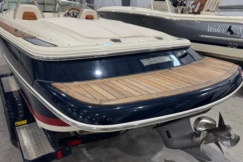 Slide: The Image of 2021 Chris-Craft Launch 23 boat with elegant wood deck and sleek design in a showroom. - 5