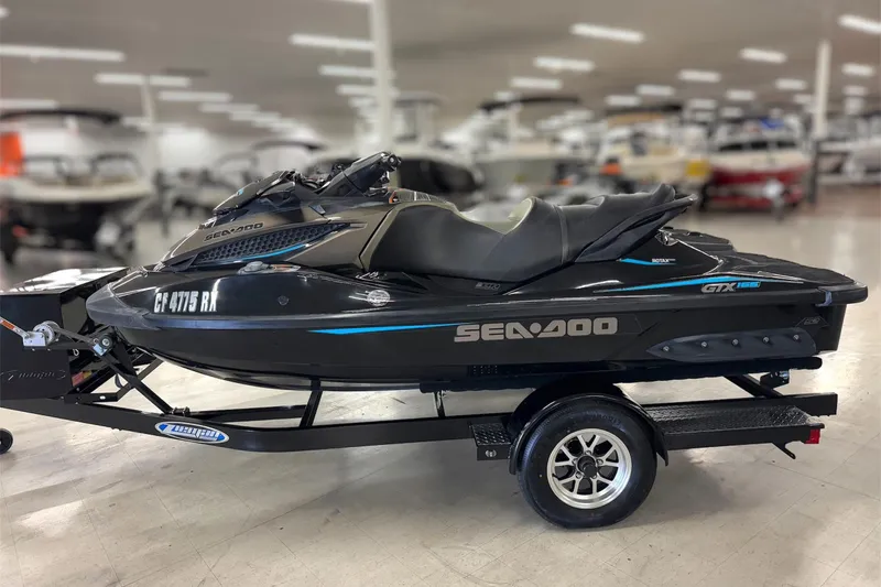 Slide: The Image of 2016 Sea-Doo GTX 155 jet ski on trailer in showroom setting. - 5