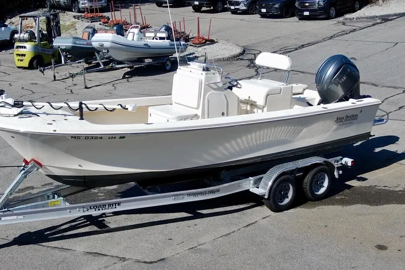Slide: The Image of Jones Brothers 2025 Cape Fisherman Lite Tackle boat on trailer in parking lot. - 2